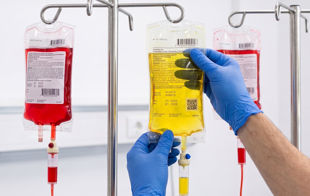 Sealed single-use IV bags being prepared with gloved hands.